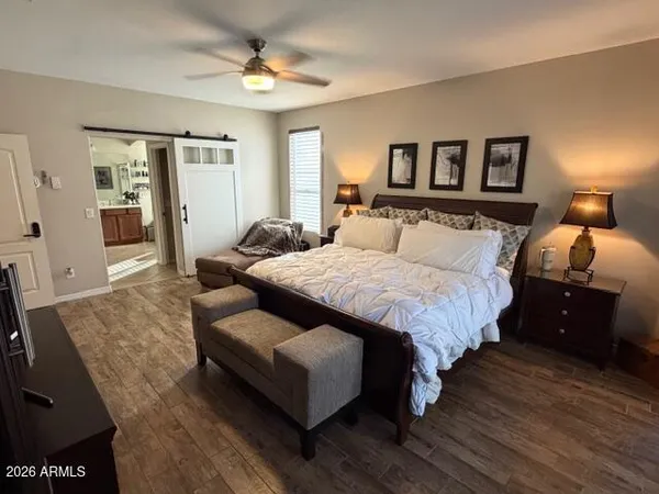 a bedroom with a bed large mirror and furniture