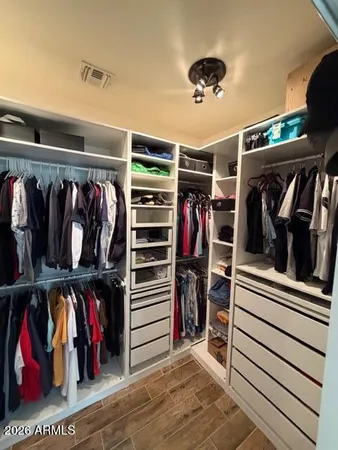 a view of walk in closet with clothes and shoes