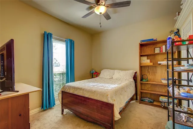 a bedroom with a bed and a flat tv screen on dresser