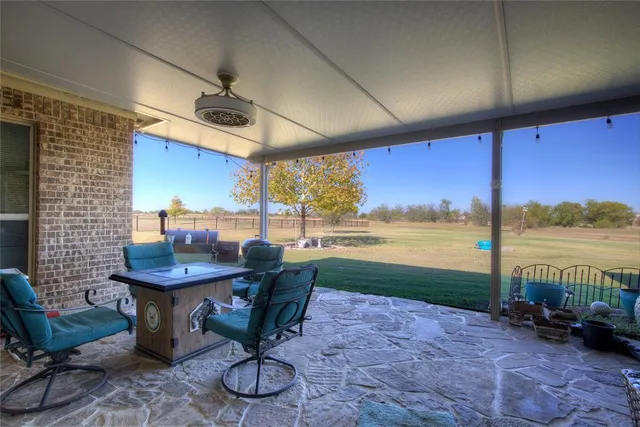 a living room with furniture floor to ceiling window and an outdoor view