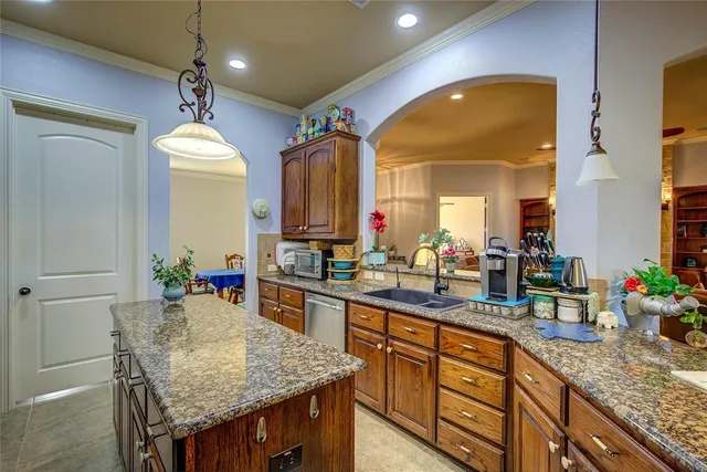 a kitchen with granite countertop a sink and a refrigerator