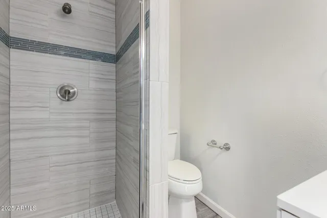 a bathroom with a toilet and a shower