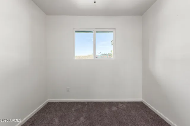 an empty room with a ceiling fan and window