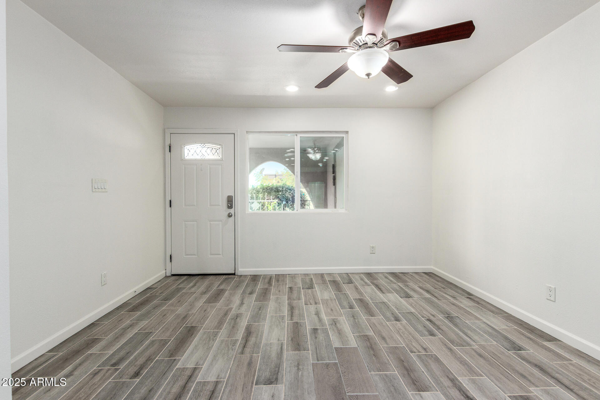 830 South Dobson Road, Unit 98 Mesa, AZ 85202 - Photo 4 of 25 an empty room with wooden floor chandelier fan and windows