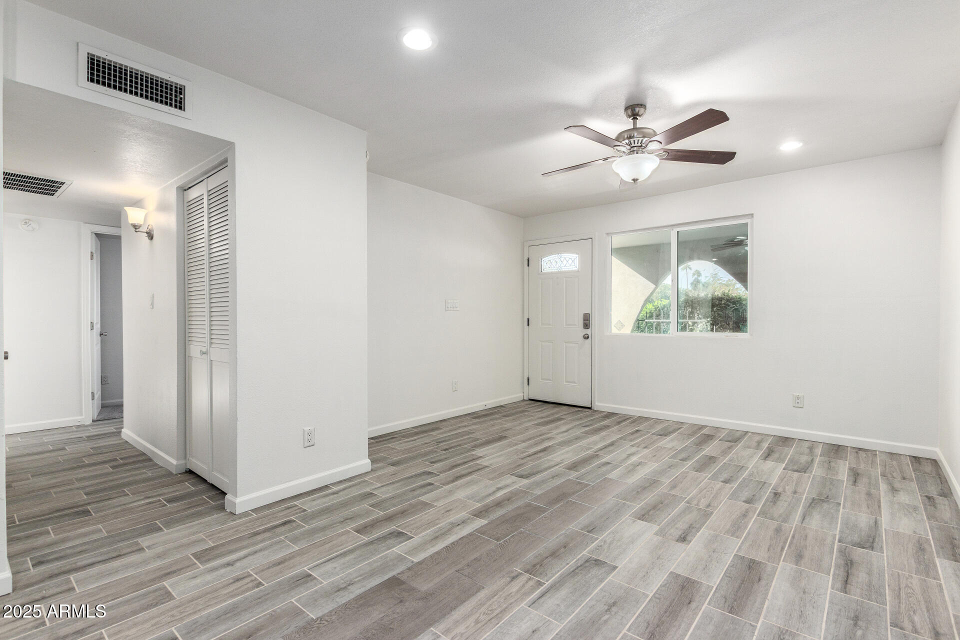 830 South Dobson Road, Unit 98 Mesa, AZ 85202 - Photo 5 of 25 a view of an empty room with wooden floor and a window