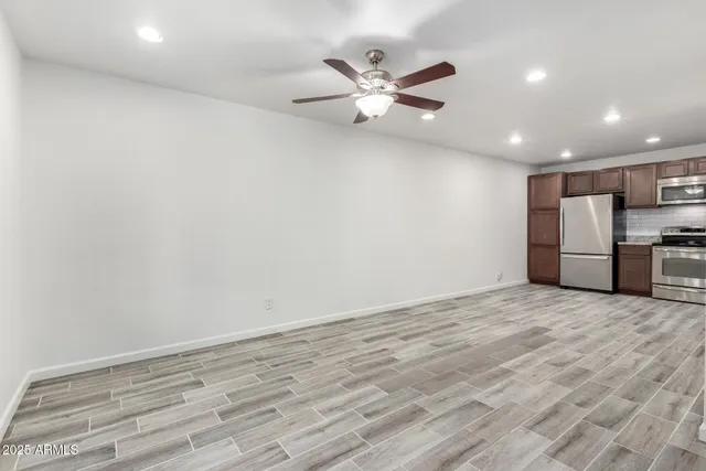 a view of a livingroom with a ceiling fan and wooden floor