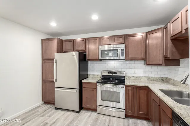 a kitchen with stainless steel appliances a refrigerator stove and sink