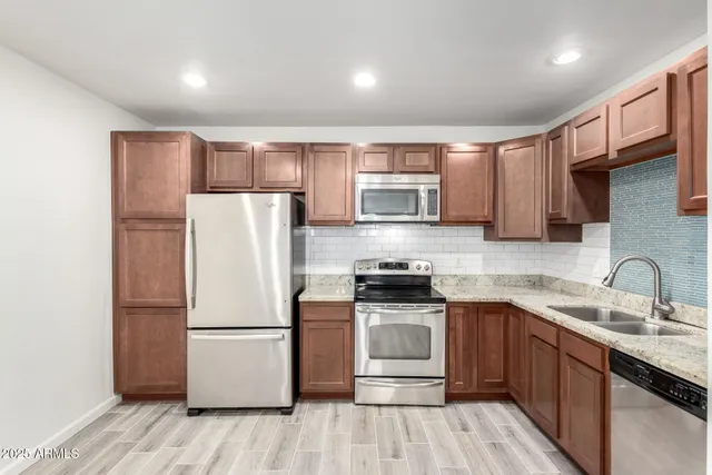 a kitchen with a refrigerator sink and wooden cabinets
