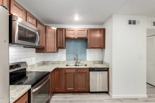 a kitchen with stainless steel appliances granite countertop a sink stove and microwave