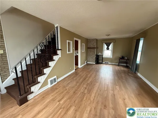 a view of a hallway with wooden floor and staircase