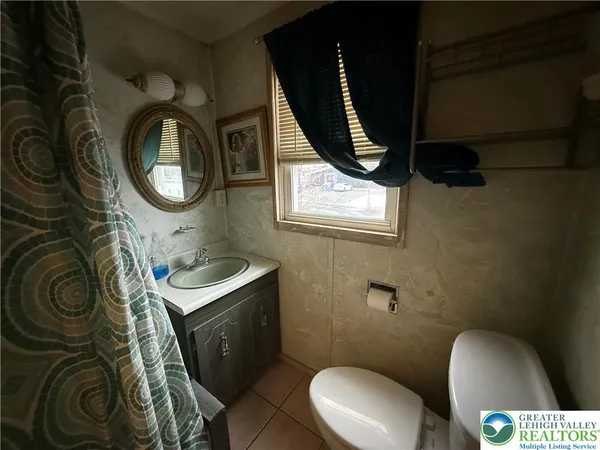 a bathroom with a toilet mirror and vanity
