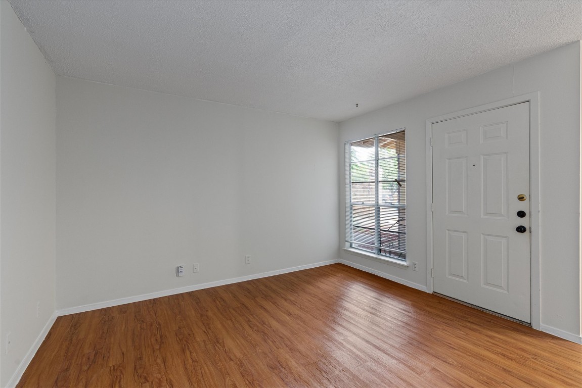 3426 Willowrun Drive, Unit B Austin, TX 78704 - Photo 5 of 16 a view of an empty room with wooden floor and window