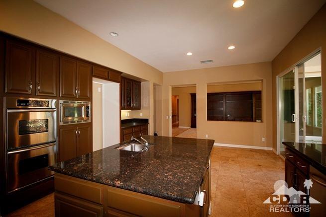 324 Loch Lomond Road Rancho Mirage, CA 92270 - Photo 12 of 51 a kitchen with stainless steel appliances granite countertop a refrigerator a stove and a sink with wooden floor