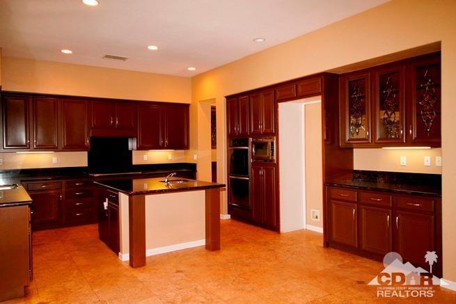 324 Loch Lomond Road Rancho Mirage, CA 92270 - Photo 14 of 51 a kitchen with stainless steel appliances granite countertop wooden cabinets and a stove top oven
