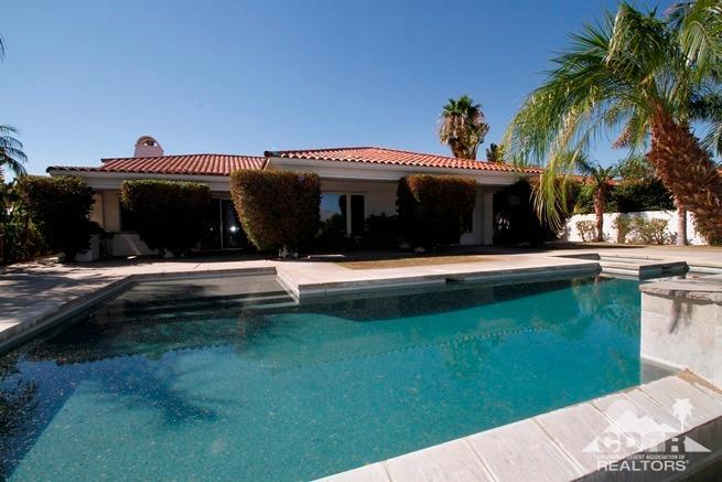 324 Loch Lomond Road Rancho Mirage, CA 92270 - Photo 46 of 51 a view of swimming pool with lawn chairs and a dining table under an umbrella