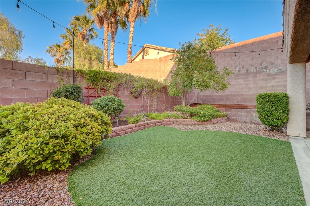 1604 Cattle Ranch Place Henderson, NV 89002 - Photo 75 of 99 A private yard with artificial turf and mature landscaping creates a tranquil outdoor retreat.