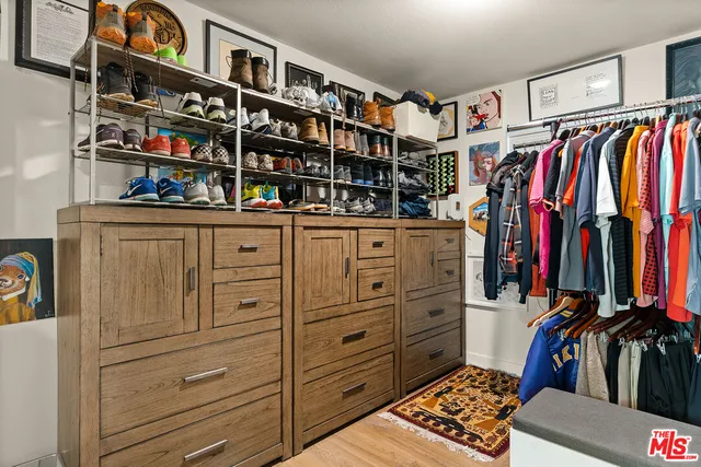 a view of walk in closet with clothes and shoes