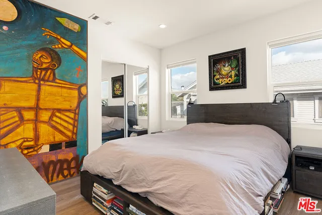 a bedroom with a bed and dresser with mirror