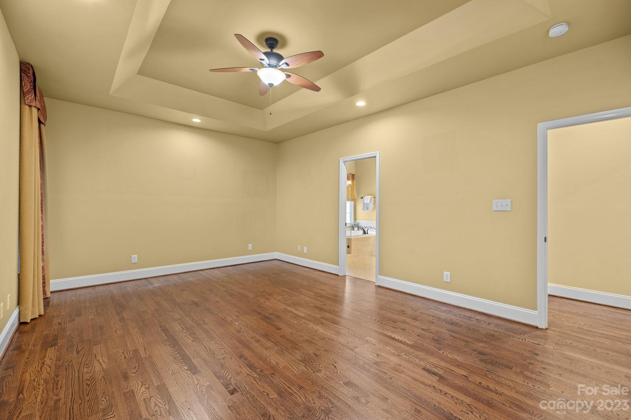 308 Gringley Hill Road Fort Mill, SC 29708 - Photo 14 of 23 an empty room with wooden floor and chandelier fan