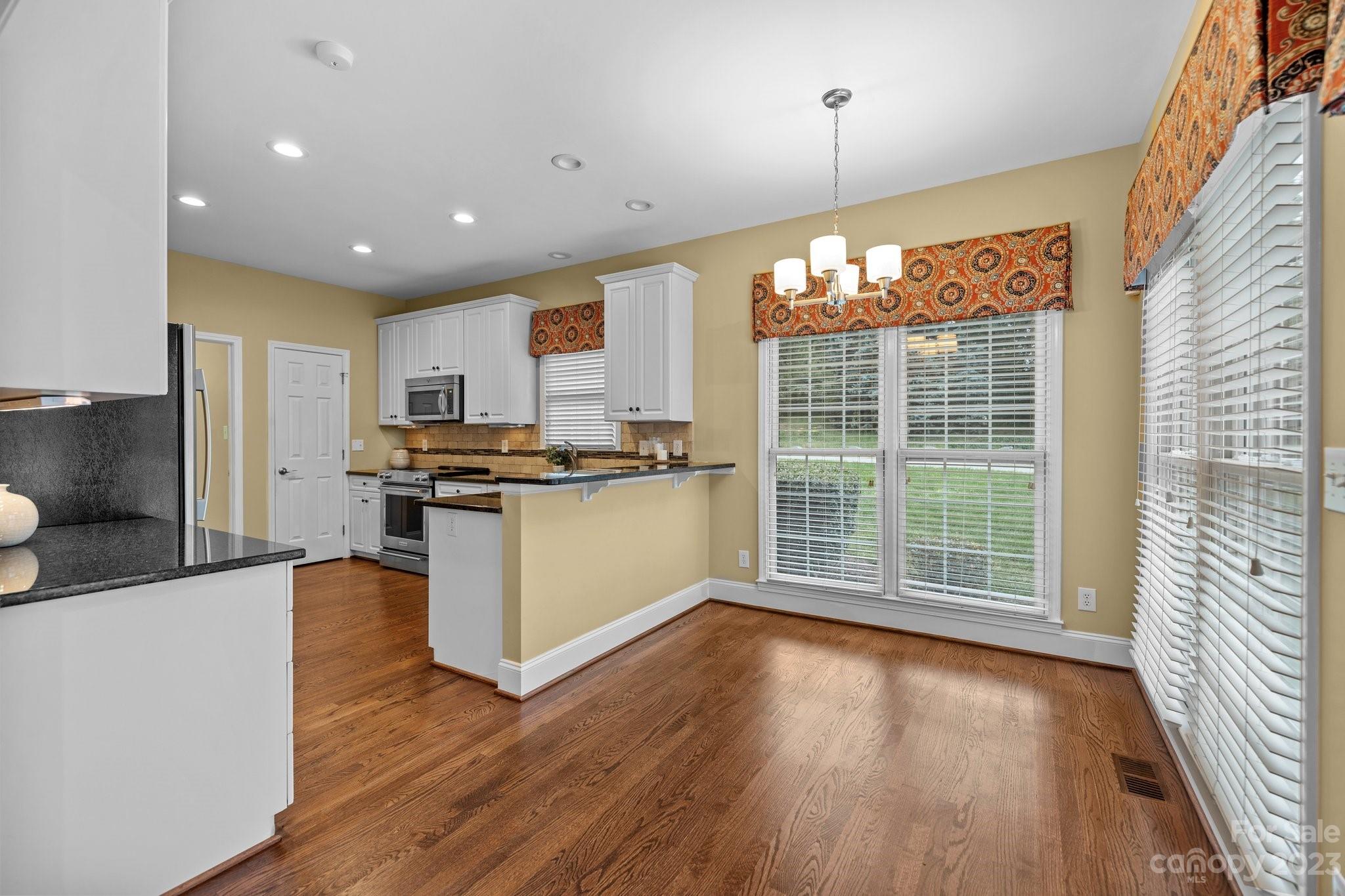 308 Gringley Hill Road Fort Mill, SC 29708 - Photo 9 of 23 a kitchen with stainless steel appliances granite countertop a refrigerator a stove top oven and a large window with wooden floor
