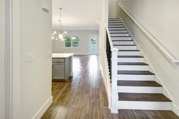 a view of a hallway with wooden floor and staircase