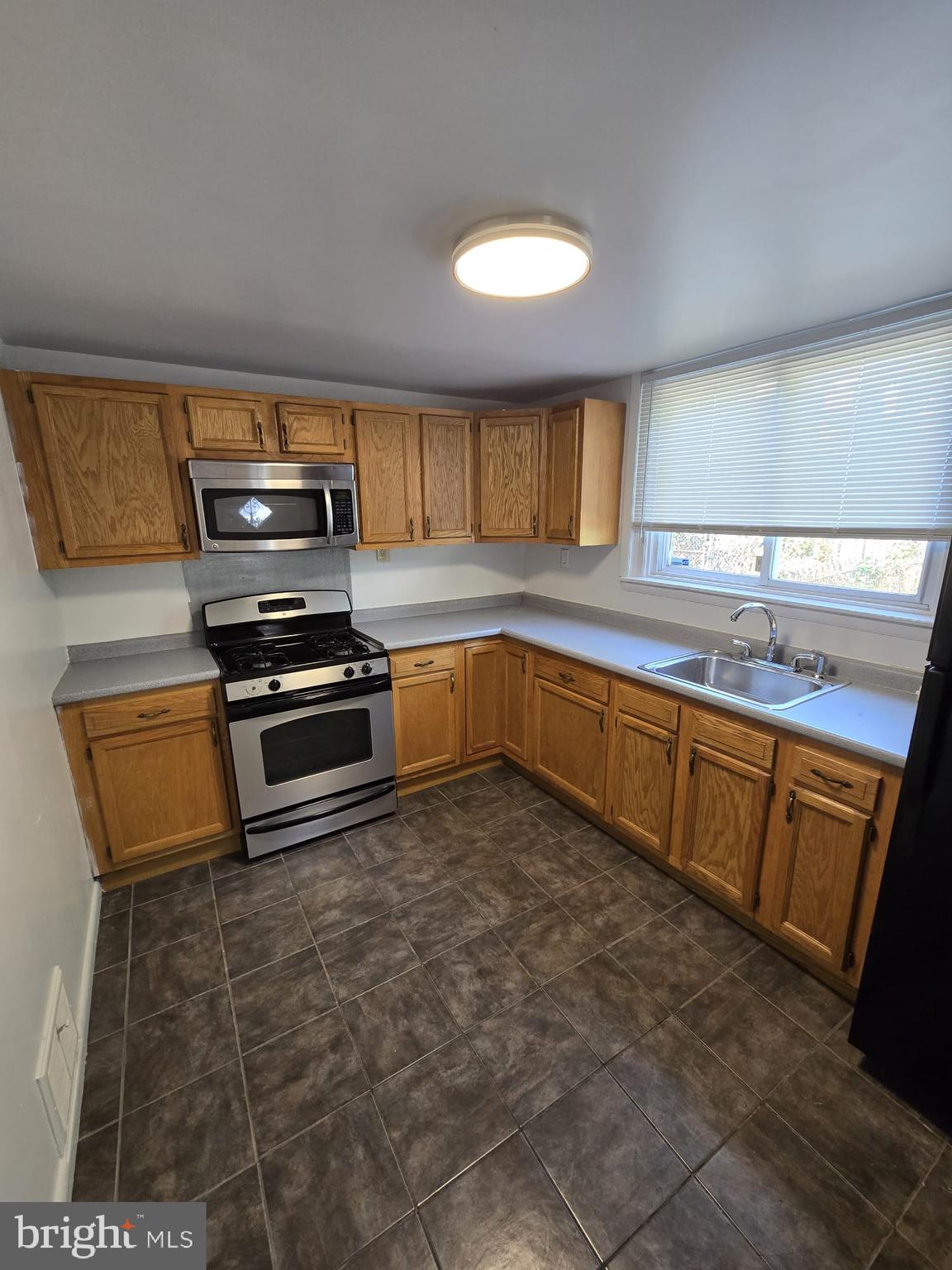 3410 North 16th Street Philadelphia, PA 19140 - Photo 11 of 20 a kitchen with stainless steel appliances a sink a stove a microwave a sink a refrigerator and cabinets