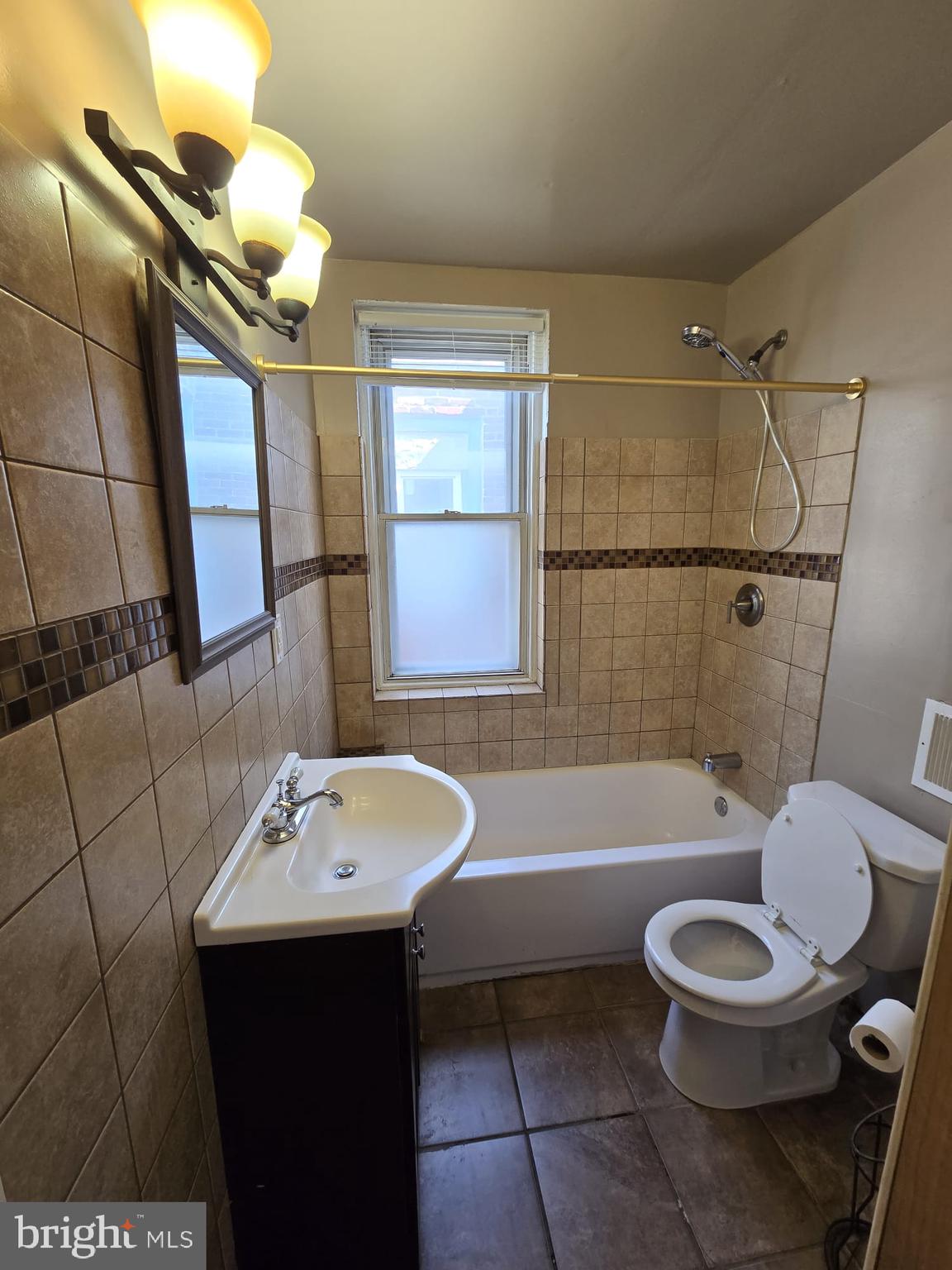 3410 North 16th Street Philadelphia, PA 19140 - Photo 16 of 20 a bathroom with a sink a toilet a mirror and bathtub