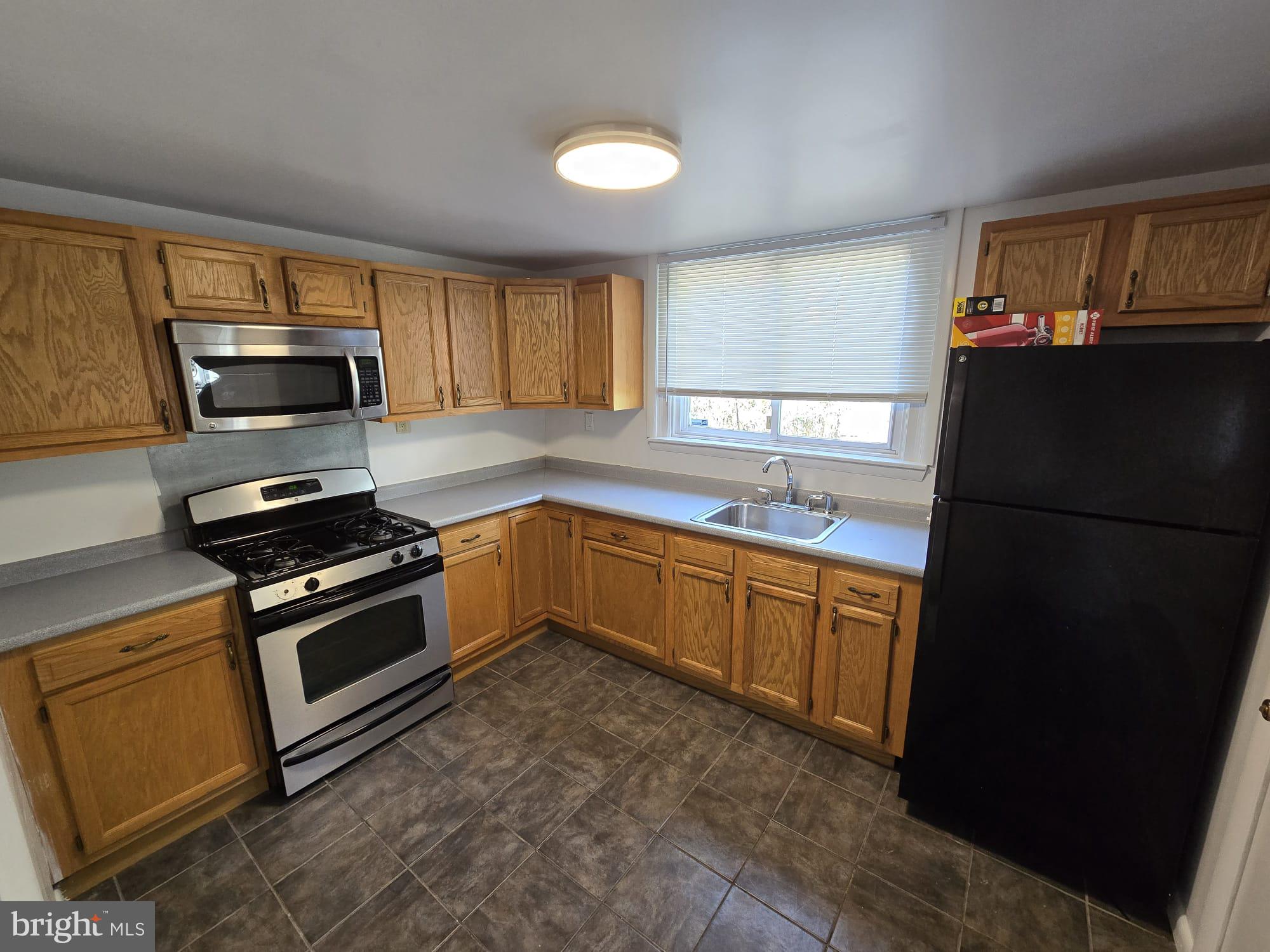 3410 North 16th Street Philadelphia, PA 19140 - Photo 10 of 20 a kitchen with a refrigerator stove and microwave