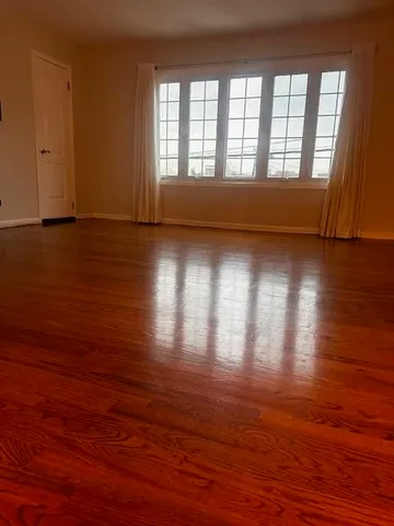 a view of room with wooden floor and windows