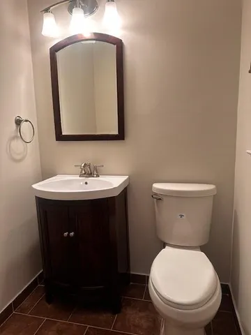 a bathroom with a toilet sink and mirror