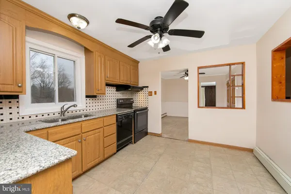 a kitchen with stainless steel appliances granite countertop a sink a stove and a refrigerator