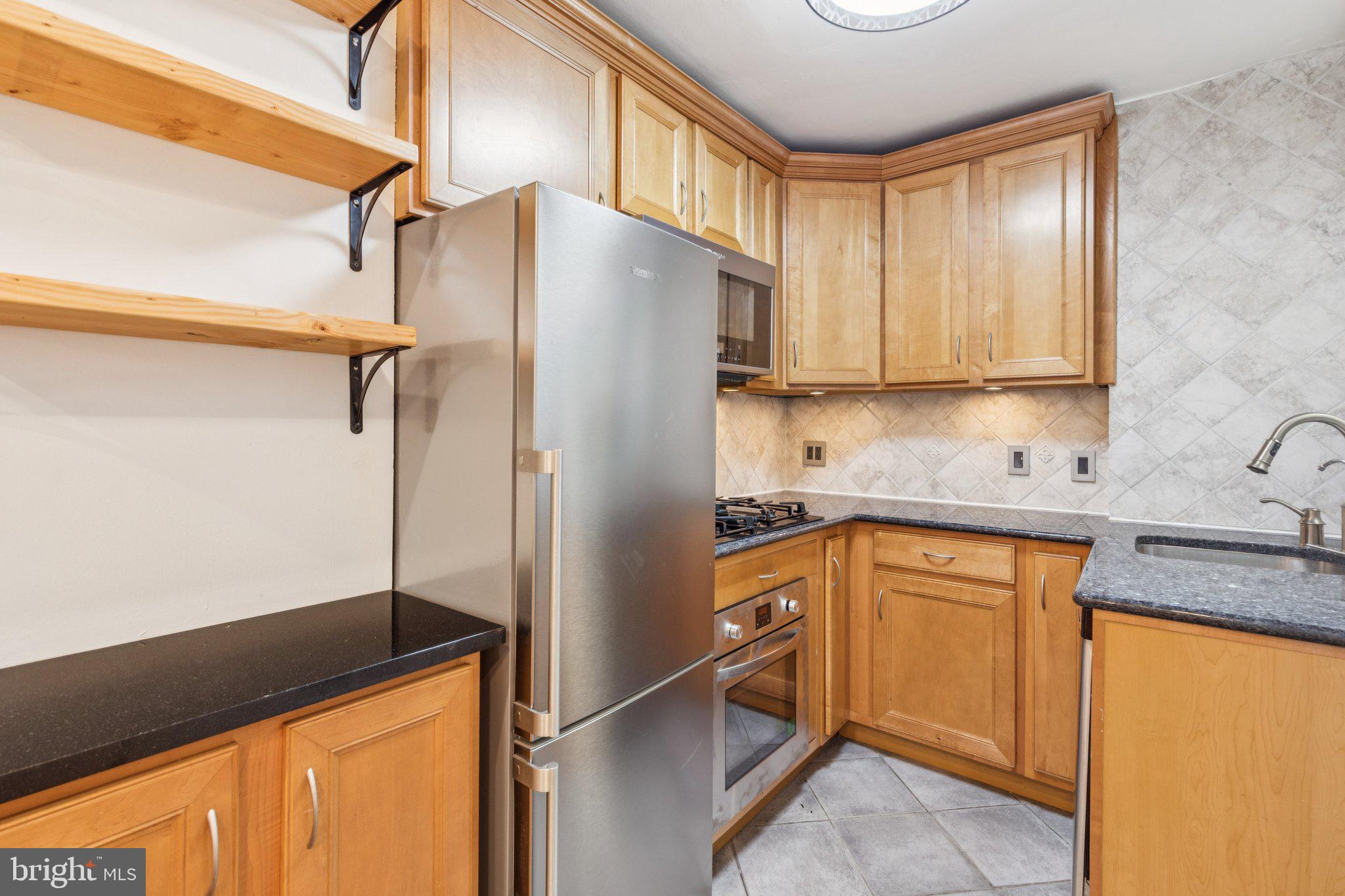 1830 R Manning Street, Unit 2 Philadelphia, PA 19103 - Photo 11 of 32 a kitchen with stainless steel appliances granite countertop a refrigerator and a sink