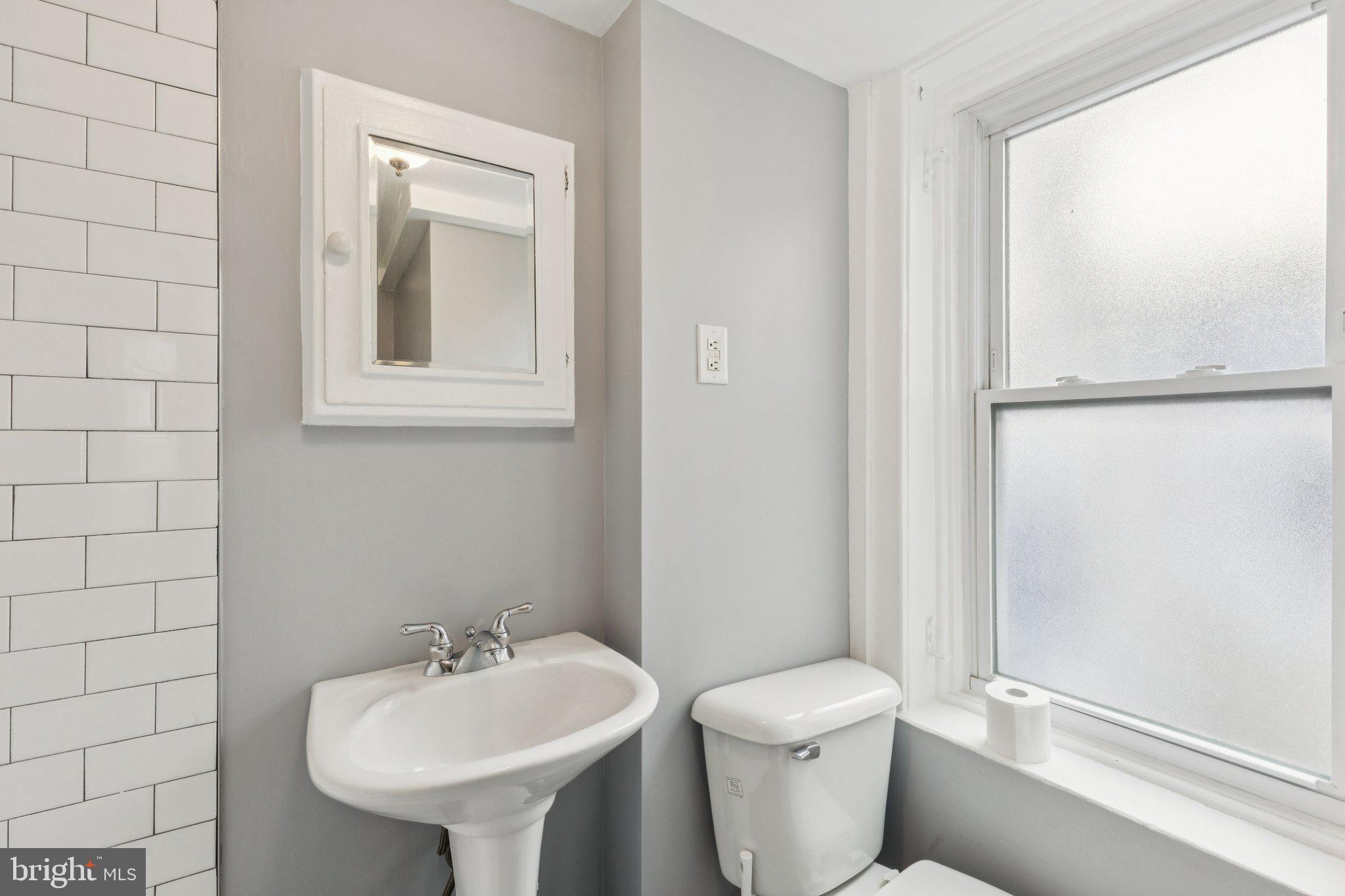1830 R Manning Street, Unit 2 Philadelphia, PA 19103 - Photo 27 of 32 a bathroom with a toilet sink and mirror