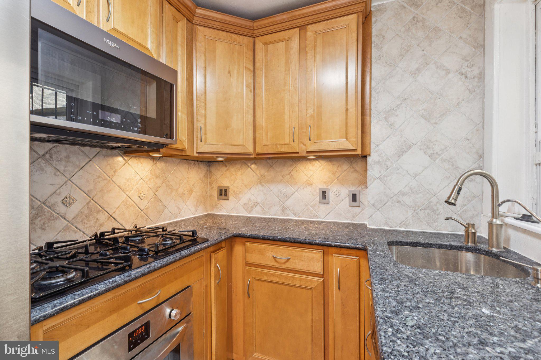 1830 R Manning Street, Unit 2 Philadelphia, PA 19103 - Photo 10 of 32 a kitchen with granite countertop cabinets stainless steel appliances and a counter space