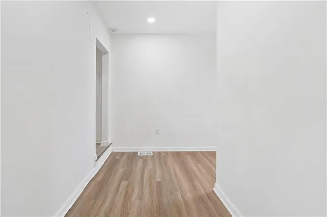 a view of a small space with wooden floor and a window
