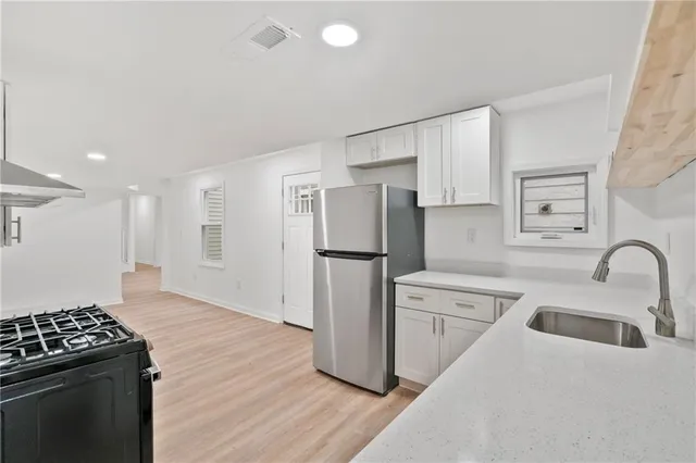 a kitchen with a refrigerator sink and cabinets