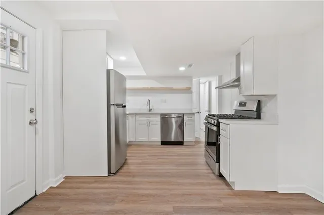 a kitchen with white cabinets and stainless steel appliances