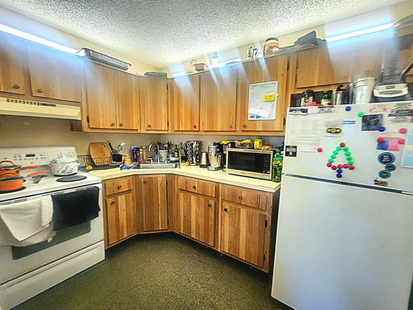 a kitchen with stainless steel appliances a stove a sink and a refrigerator