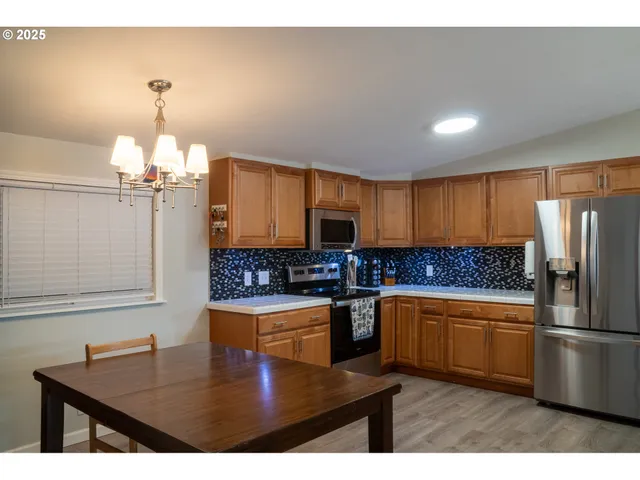 a kitchen with stainless steel appliances granite countertop a sink refrigerator and cabinets
