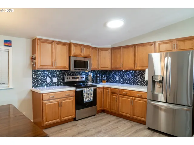 a kitchen with stainless steel appliances granite countertop a refrigerator stove microwave sink and cabinets