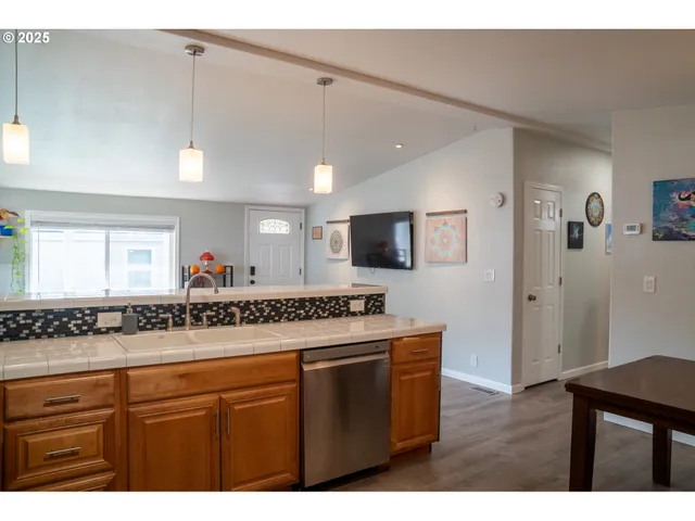 a kitchen with stainless steel appliances granite countertop a sink and a wooden cabinets
