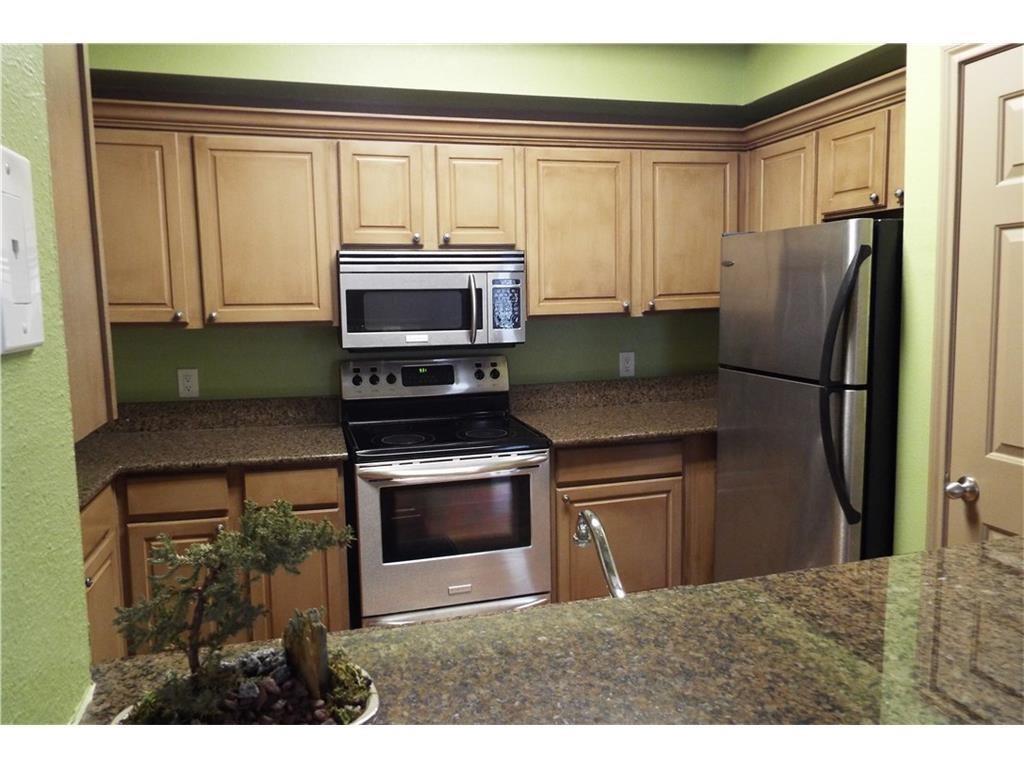 2601 Preston Road, Unit 5209 Plano, TX 75093 - Photo 7 of 18 a kitchen with stainless steel appliances granite countertop a refrigerator a stove a sink and a microwave