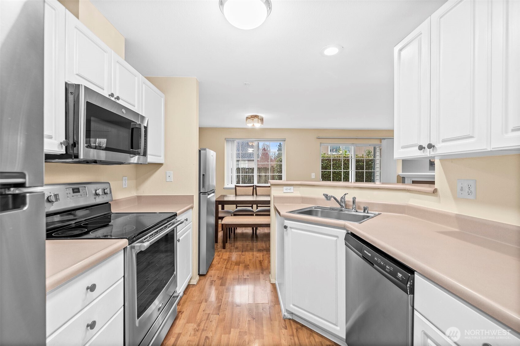 10824 Southeast 170th Street, Unit B103 Renton, WA 98055 - Photo 12 of 31 a kitchen with stainless steel appliances a stove sink microwave and cabinets