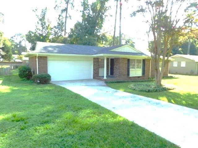 front view of a house with a yard and an trees