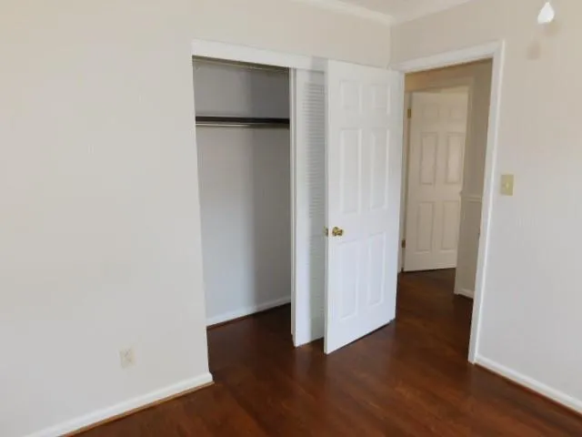 an empty room with wooden floor and closet