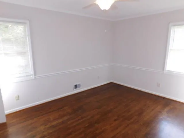 an empty room with wooden floor and window