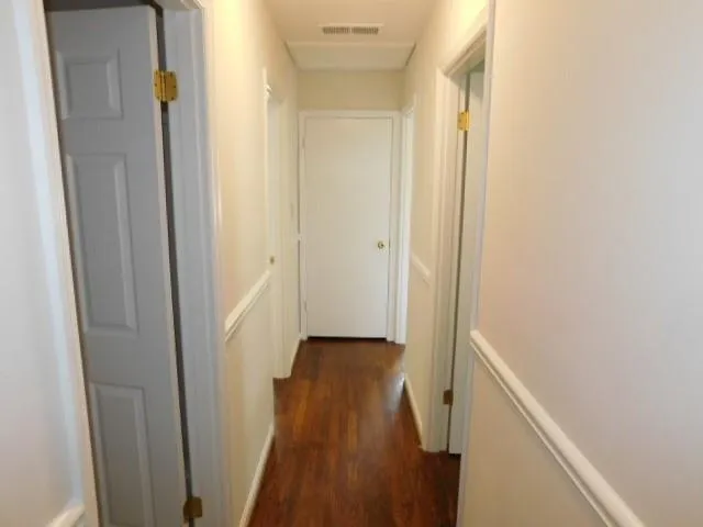 a view of a hallway with wooden floor