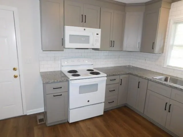 a view of cabinets a sink and wooden floor