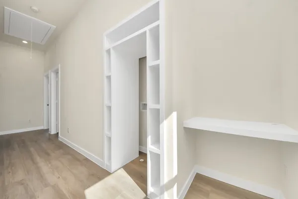 an empty room with a window and ceiling fan