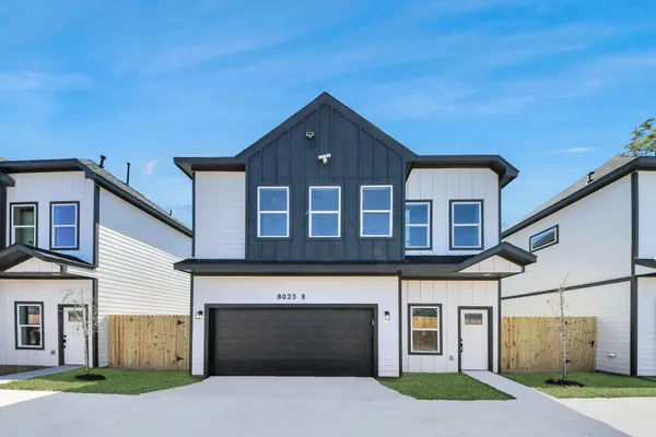 a front view of a house with yard and parking